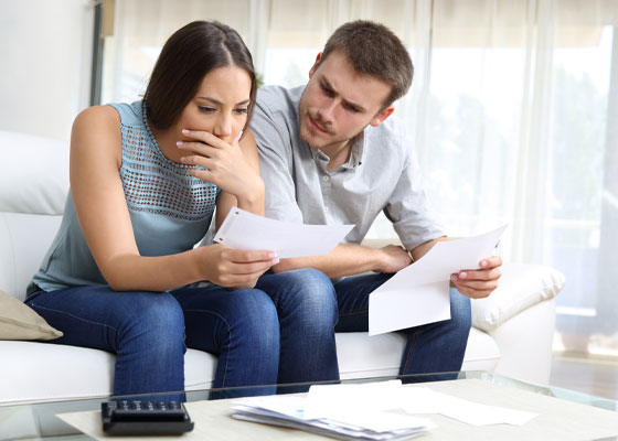 stockphoto male female couple on couch looking at paper